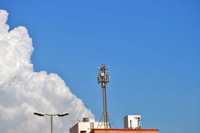 Low angle view of communications tower against blue sky