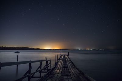 Illuminated road against sky at night