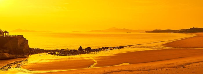 Scenic view of beach against sky during sunset