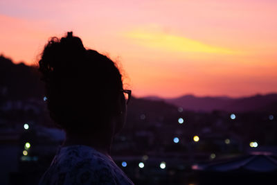 Rear view of silhouette man looking at sunset