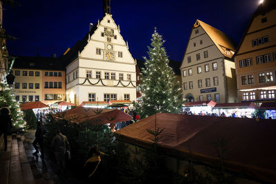 Rear view of people walking on street in city