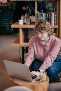 Young woman using laptop at cafe