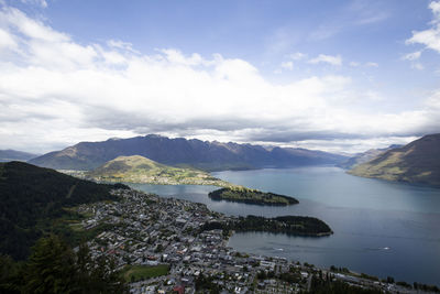 Aerial view of townscape by mountains against sky