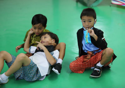 Portrait of happy friends sitting at school in thailand .