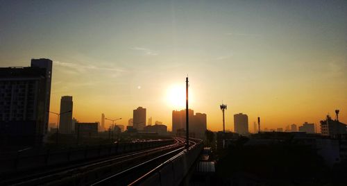 Buildings in city against sky during sunset