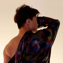 Portrait of young man looking away against wall