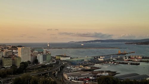 High angle view of cityscape by sea against sky