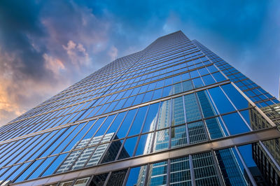 Low angle view of glass building against sky