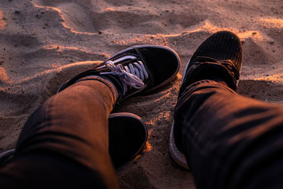 Low section of man relaxing on sand