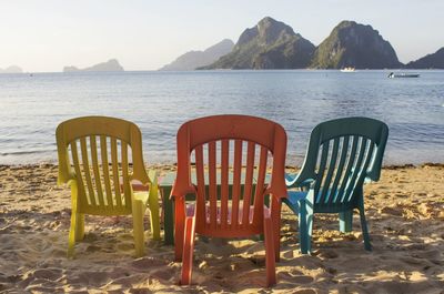 Chairs on beach against sea