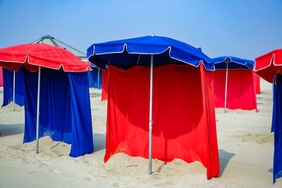 Red flags on beach against clear blue sky