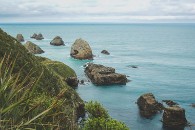 Scenic view of rocks in sea against sky