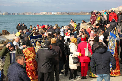 Rear view of people standing by sea