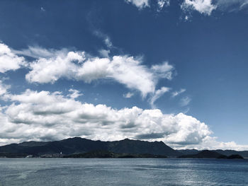 Scenic view of sea and mountains against sky