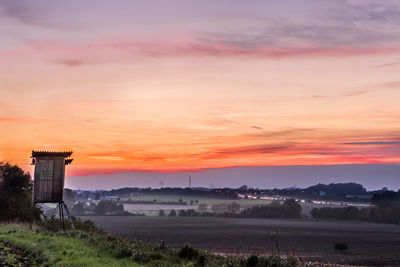 Scenic view of field against orange sky