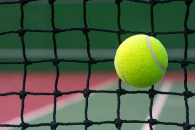 Close-up of tennis ball against net