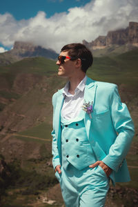 Fashionable portrait of the groom waiting for the bride. stylish groom in sunglasses and a turquoise