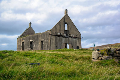 Old building on field against sky