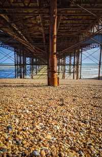 Picture of beams and supports of a pier on a pebble beach in the late afternoon of spring