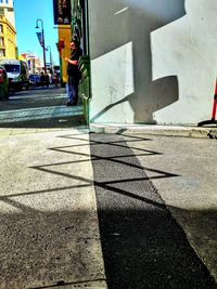 Shadow of people walking on street by building