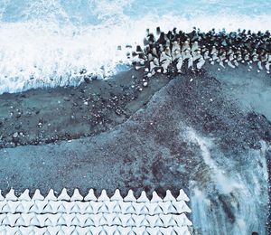 High angle view of stone wall by sea