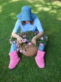 High angle view of woman with pink flowers on field