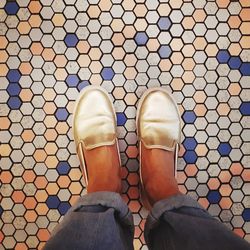 Low section of man standing on tiled floor