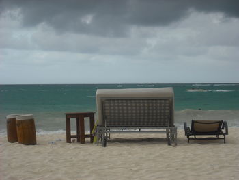 Chairs on beach against sky