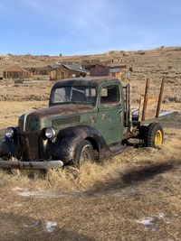 Abandoned truck on field against sky