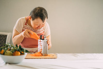 Lifestyle, education. an elderly woman with down syndrome is studying in the kitchen or classroom