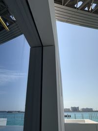 Low angle view of louvre museum building and its reflection against clear blue sky in abu dhabi.