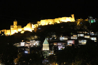 High angle view of buildings lit up at night