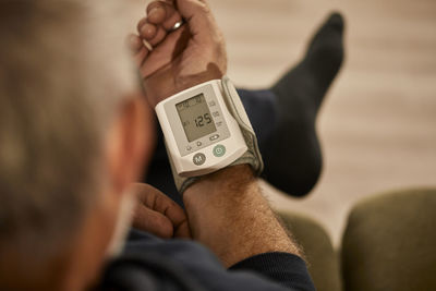 Man measuring blood pressure at home