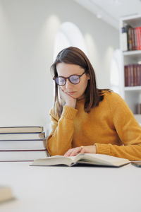 Portrait of young woman reading book