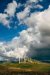 Windmill on field against sky