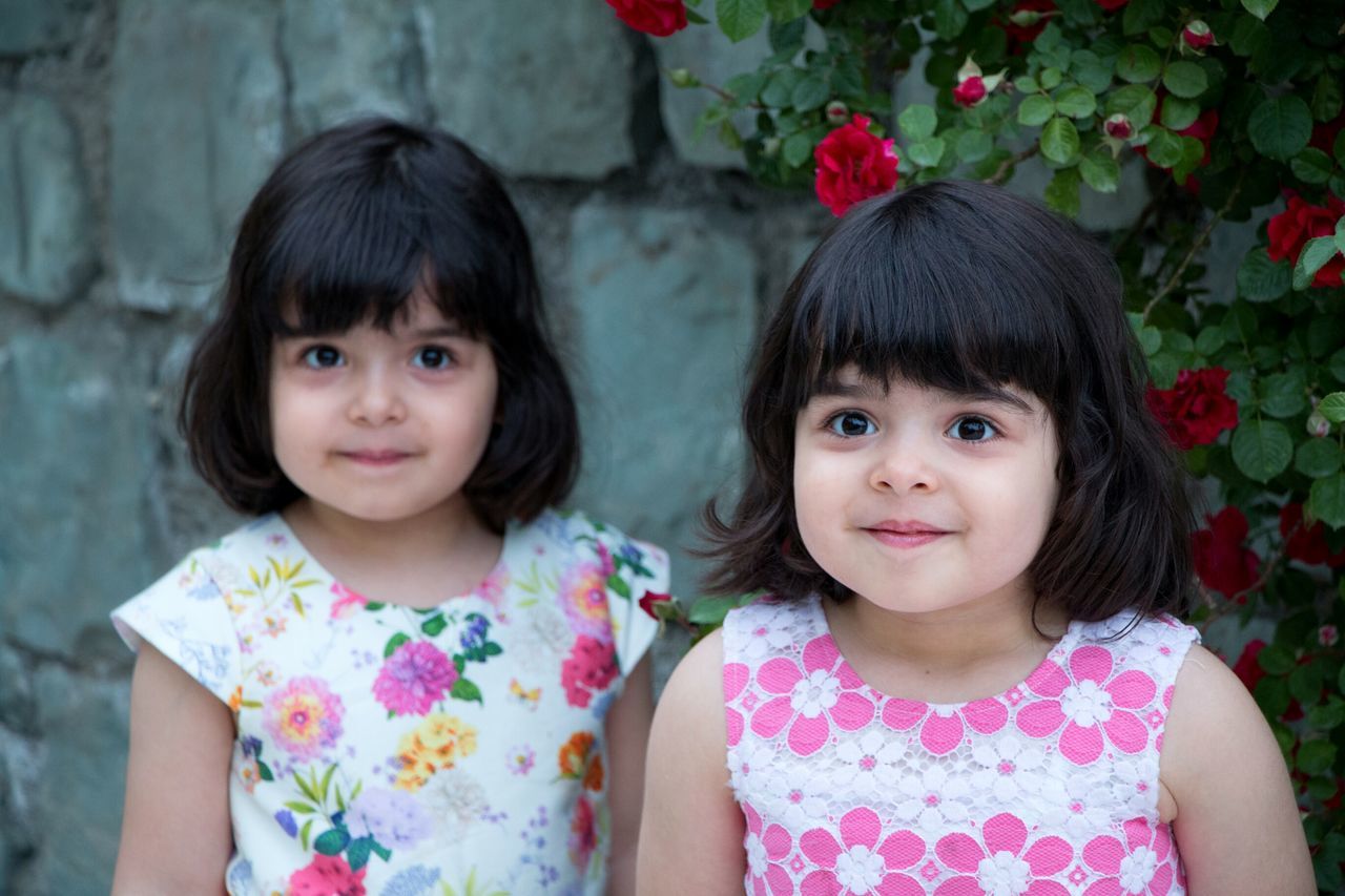 girls, looking at camera, two people, portrait, childhood, real people, togetherness, sibling, flower, outdoors, day, bonding, smiling, friendship, child, close-up, people