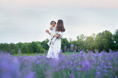 Woman standing on field with purple flowers