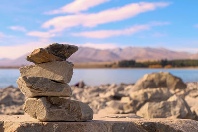 Stack of stones in sea against sky