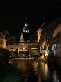 Arch bridge over river in city at night