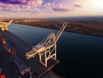 High angle view of cranes by river at harbor
