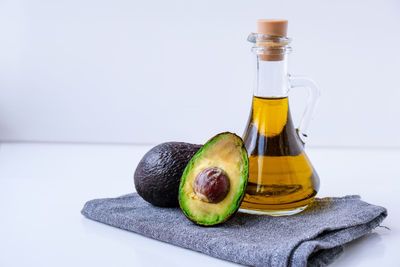 Pitcher of natural oil and fresh ripe hass avocados. preparing food in the kitchen. ingredients. 