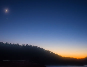 Scenic view of silhouette field against clear sky at night