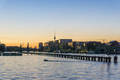 View of city at waterfront during sunset