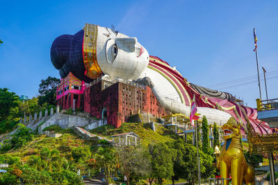 Low angle view of carousel against clear blue sky