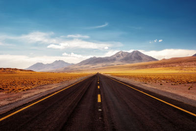 Empty road along countryside landscape