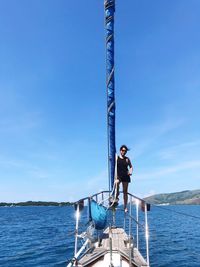 Man on boat against blue sea against sky