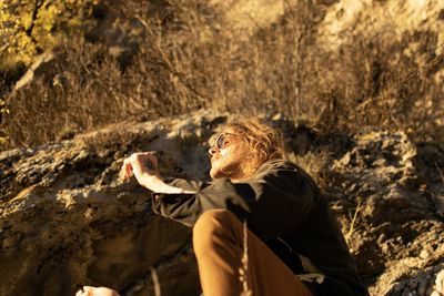 Young man looking away on rock