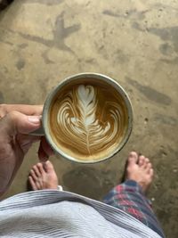 Low section of woman holding coffee cup