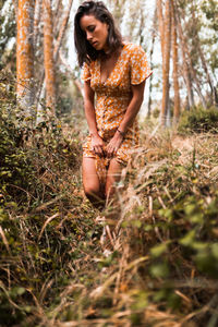 Close up of young woman looking down while standing in forest