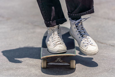 Low section of man skateboarding on street